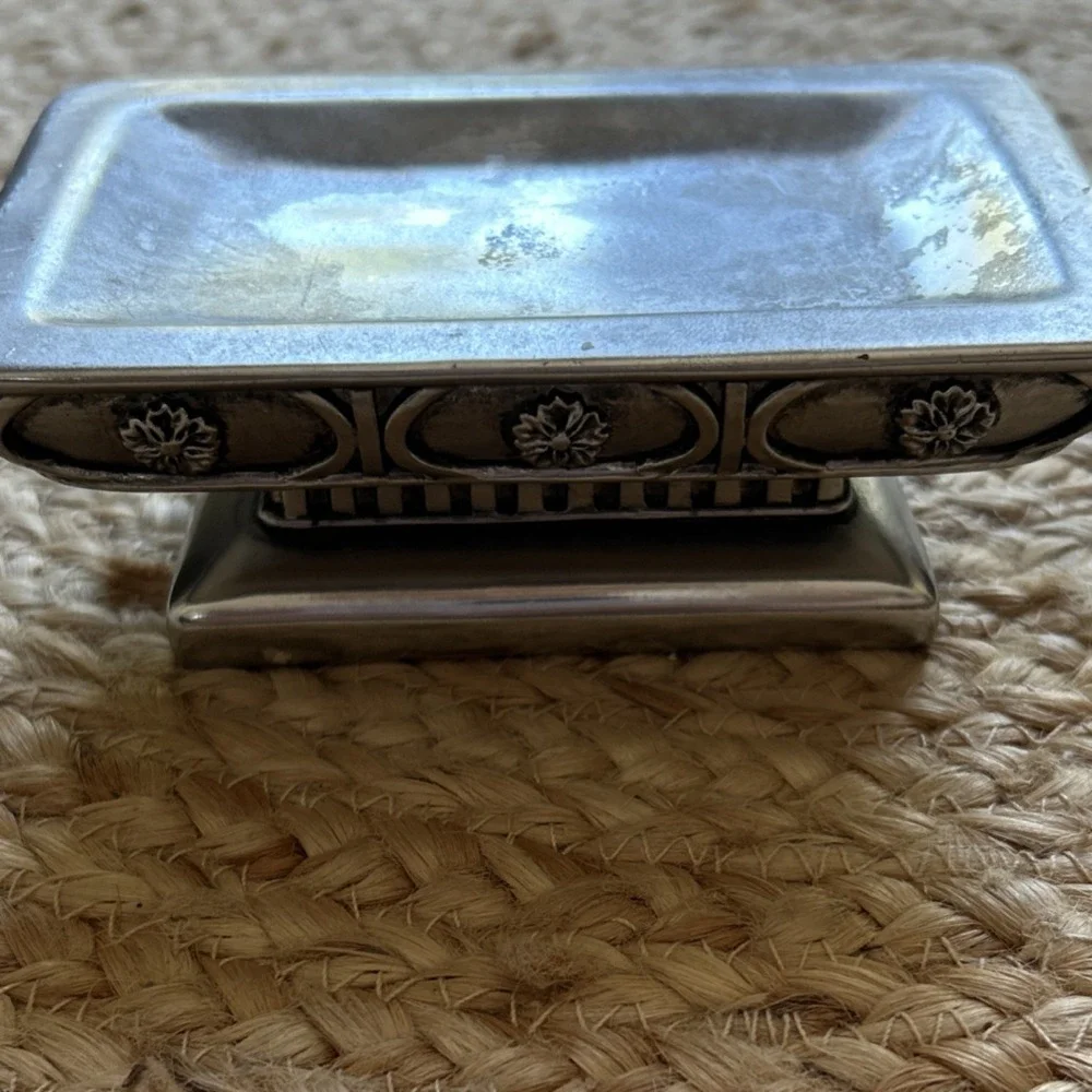 decorative silver-tone pedestal dish, likely used as a soap dish, trinket holder
